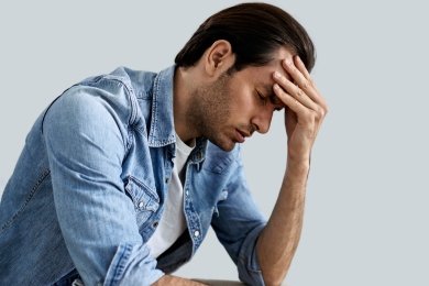 young man having headache and anxiety holding his head pain